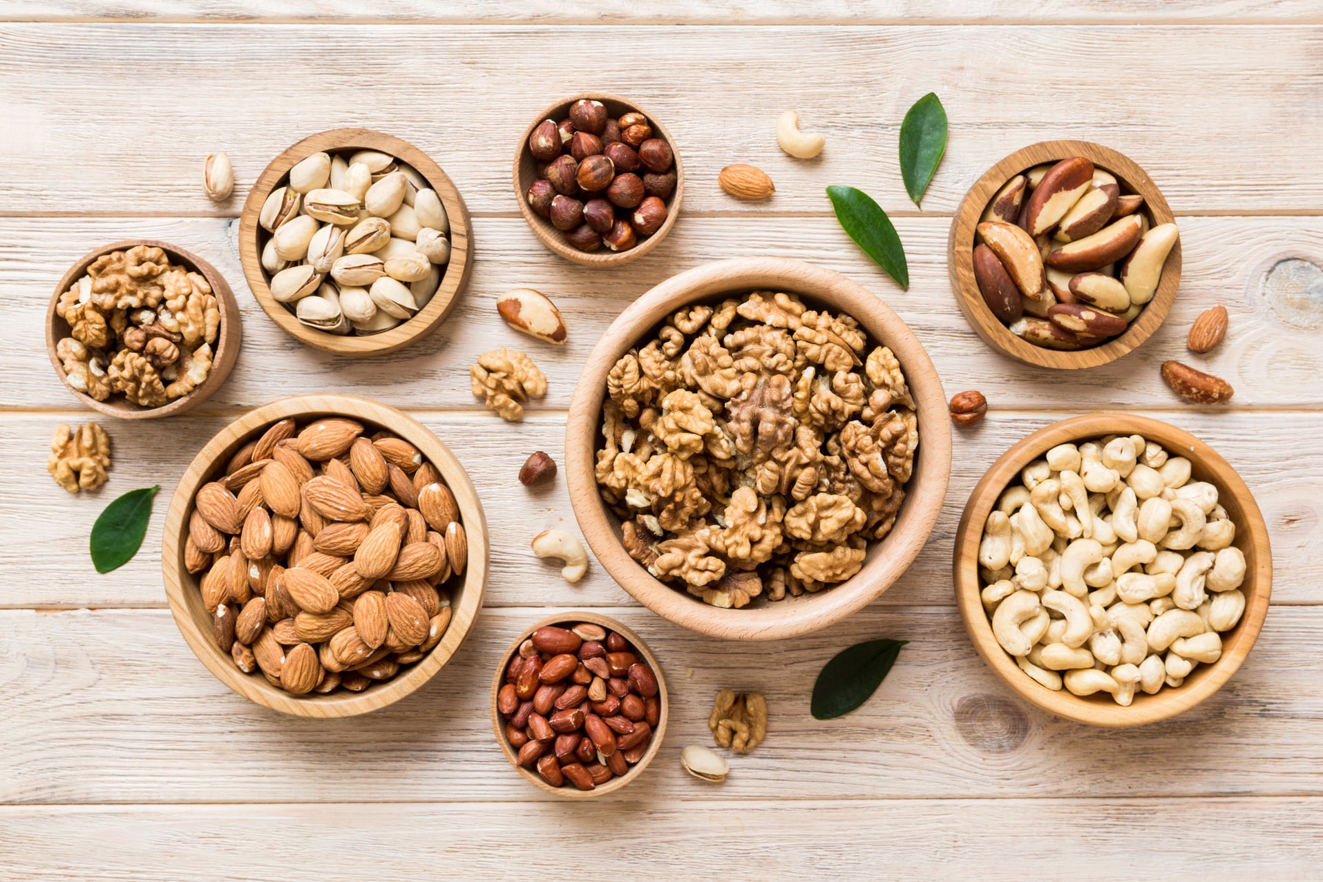 mixed nuts in wooden bowl. Mix of various nuts on colored background. pistachios, cashews, walnuts, hazelnuts, peanuts and brazil nuts
